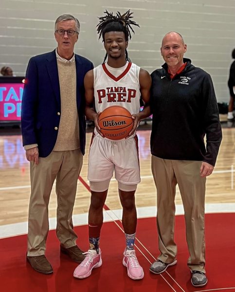 Chandler White Brooks stands next to head coach Joe Fenlon and athletic director Chris Lavoie as he is honored for reaching 1,000 career points.
