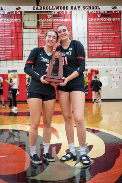 Senior Grace Heller and Junior Julianna Manno show off the District championship trophy after the game. 